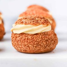 several pastries with icing sitting on a white surface