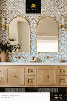 a bathroom with blue and white tiles on the wall, two mirrors above the sink