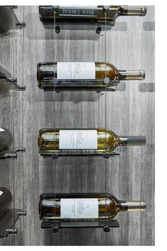 several bottles of wine are lined up in a row on the wall next to each other