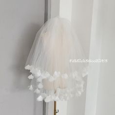 a white veil hanging from the side of a door