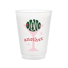 a shot glass with the words olive and another in red letters on it, against a white background