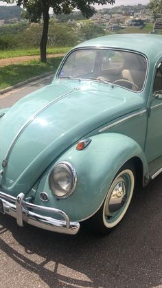 an old blue car parked in a parking lot