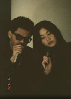 a man and woman sitting next to each other with a microphone in front of them