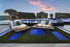 an outdoor living area with couches and fire pit