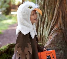 a young boy dressed as a bird with a book in his hand