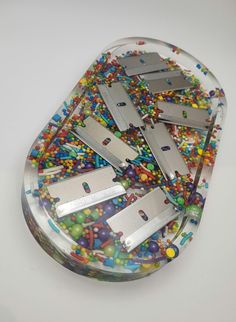 there are many small pieces of metal on this plate with beads and confetti all over it