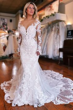 a woman in a white wedding dress standing on a wooden floor