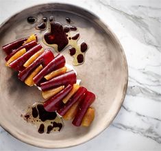 some food is on a silver plate with sauces and fruit slices in the middle