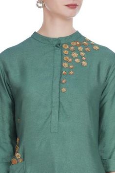 For a traditional look at work, pick this green silk blend tunic. It features 3D flower motif embroidery. Team it up with gold-toned pants to complete the look. 
Mandarin collar
Utility pockets
Three quarter sleeves - Aza Fashions Green Slub Silk Designer Dress, Traditional Chanderi Kurta With Embroidered Neckline, Green Slub Silk Straight Kurta Dress, Green Slub Silk Dress With Traditional Drape, Green Straight Kurta Sets With Embroidered Neckline, Festive Anarkali Top With Embroidered Neckline, Embroidered Green Cotton Silk Kurta, Green Embroidered Cotton Silk Kurta, Festive Green Kurta With Embroidered Neckline