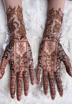 two hands with henna designs on them