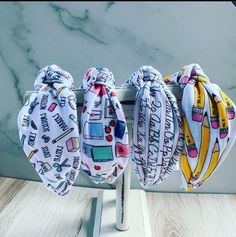 three bandanas are hanging on a metal rack in front of a marble counter top