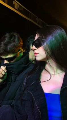 two women standing next to each other wearing sunglasses