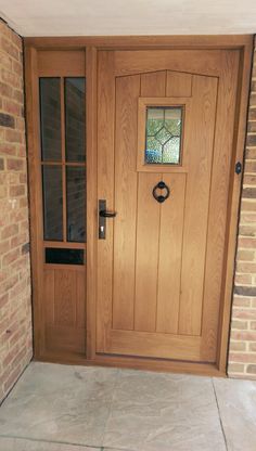 a wooden door with two sidelights on the outside of a brick wall and stone floor