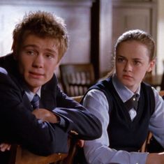 two young people sitting at desks with their arms crossed and looking off to the side