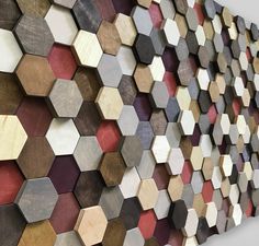 a large wooden wall sculpture made out of hexagonal wood pieces with different colors