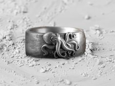 Enigmatic Octopus's Embrace, Men's Oxidized Silver Tale, Mythical Nuptial Symbol, Artisan's Underwater Design, Sterling Creature Band Enhancing your everyday grace, this wedding band accompanies you from the first chapter of your beautiful journey. Forged with affection and happiness from the finest materials, its presence will be a constant through the years. It stands poised to become a generational treasure, a piece of family history! The ring's detailed handcraftsmanship guarantees it's a head-turner, making this silver adornment not just a pledge of love but also an ideal offering for those closest to your heart. -Gender : Unisex -Stamp: 925k Sterling Silver -Finish: Oxidized - Polished - Gold Plated - Ring Diameter: 1.10 cm (0.44 inches) - Ring Weight: 16.00 - 16.50 Gr ( For USA Ring Bear Face Drawing, Underwater Design, Plated Ring, Gold Plated Rings, Oxidized Silver, Family History, Rings Statement, Octopus, Wedding Band