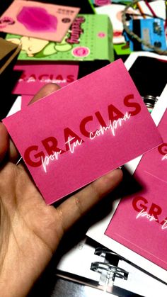 a person holding up some pink cards with the word gracias written on them