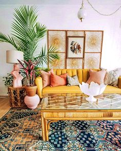 a living room filled with lots of furniture next to a wall covered in pictures and plants