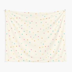 a white wall tapestry with multicolored polka dots