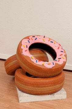 two wooden tires stacked on top of each other with pink frosting and sprinkles