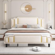 a white bed with gold trim around the headboard and foot board in a bedroom