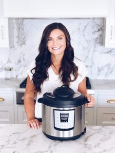 a woman standing in front of an instant pot