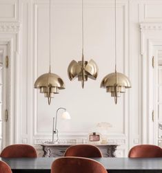 a dining room table with chairs and lamps hanging from the ceiling