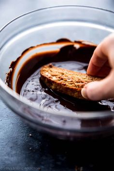 someone is dipping something into some chocolate in a bowl