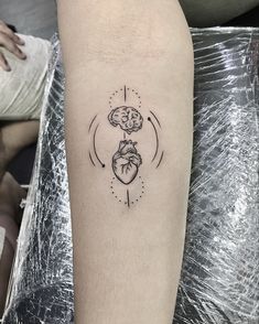 a heart and brain tattoo on the arm