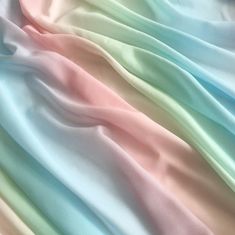 multicolored satin fabric close up with soft folds in the center and on top