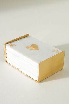 a stack of white and gold coasters with hearts on them