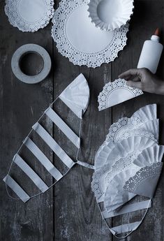 white paper doily and other crafting supplies laid out on a wooden table