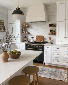 a kitchen with white cabinets and wooden stools in front of an island countertop