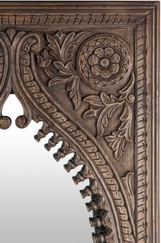 an intricately carved wooden mirror frame