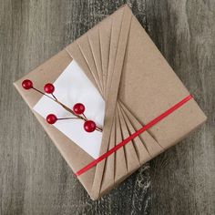 a brown box with red berries on it and some white paper tied to the side