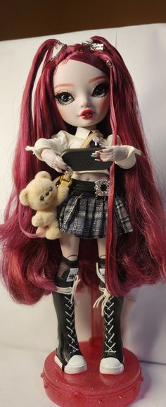 a doll with red hair holding two teddy bears