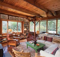 a living room filled with lots of furniture next to a window covered in bookshelves