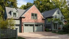 a large brick house with two garages on the front and one car in the driveway