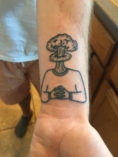 a person's arm with a tattoo on it that has an image of a mushroom