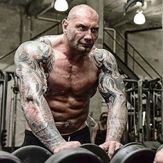 a tattooed man working out in the gym