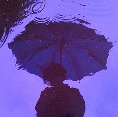 an umbrella is reflected in the water on a rainy day