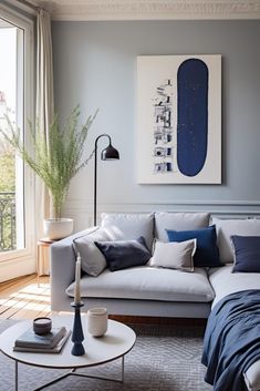 a living room filled with furniture and a painting on the wall over a couch next to a coffee table