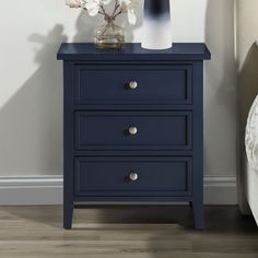 a night stand with three drawers and a vase on top