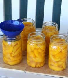 four jars filled with sliced bananas on top of a wooden table