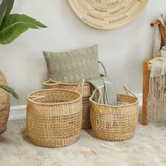 three woven baskets sitting next to each other on the floor in front of a wall