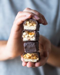 a person holding some kind of chocolate bar in their hands with walnuts on top