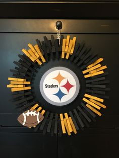 a wreath made out of sticks and footballs is hanging on the door to decorate it