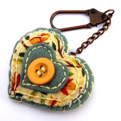 a heart shaped keychain with a button on it