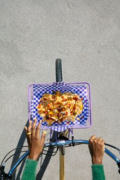 a person riding a bike with a plate on it's front wheel and hands holding onto the handlebars