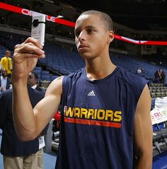 a man taking a selfie with his cell phone at a sporting event in an arena